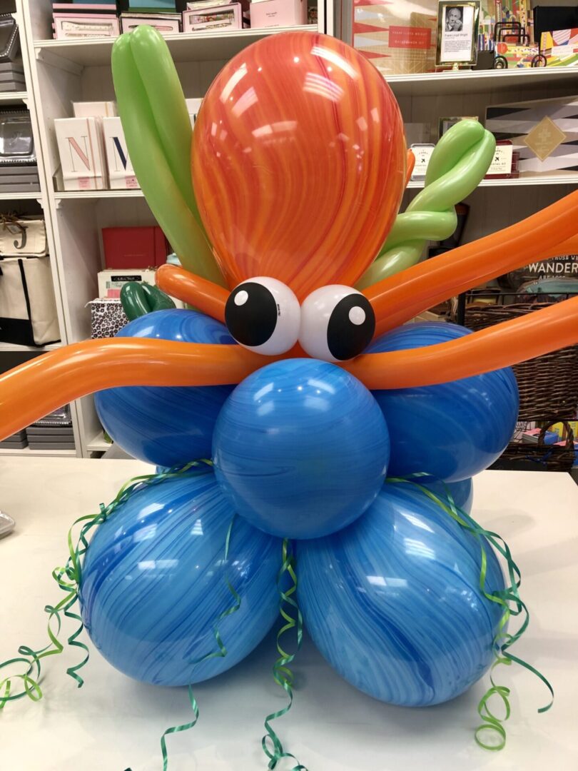 A balloon sculpture of an octopus with orange and green hair.
